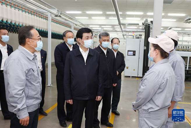 图为王沪寧23日在新疆一工厂与职工交谈。（图／新华社）