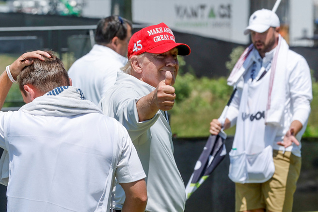 美国前总统川普25日参加一场高尔夫球赛，打完18洞后朝一旁的记者竖起大拇指，似乎对自己的表现相当满意。（图／路透）