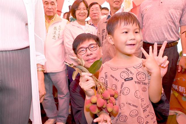 高雄市长陈其迈（中）27日出席大树区凤荔节活动，他与孩童互动。（林瑞益摄）