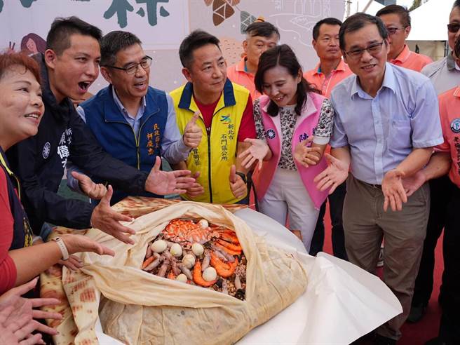 新北市石门区公所今日睽违3年举办「新北第一粽」农特产品行销推广活动，现场准备了一颗百斤大肉粽，内含花蟹、小卷、虾子等山珍海味，吸引大批民眾排队，抢拍之余也想嚐鲜。（蔡雯如摄）