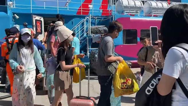 受到玛娃颱风外围环流影响，台东往返绿岛的船班今天中午后全部停航，许多游客搭船返回台东。（蔡旻妤摄）