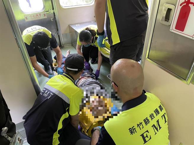 一名年约72岁男子不明原因倒卧铁轨旁，司机员见状报案，消防员将老翁送上火车抵达荣华站后由救护车送往医院。（新竹县消防局提供／邱立雅竹县传真）