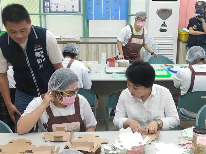 台中市长卢秀燕29日上午到雾峰区「旧省政府教育厅」视察身障小作所及长青学苑，现场向身障学员学起包装产品。（潘虹恩摄）