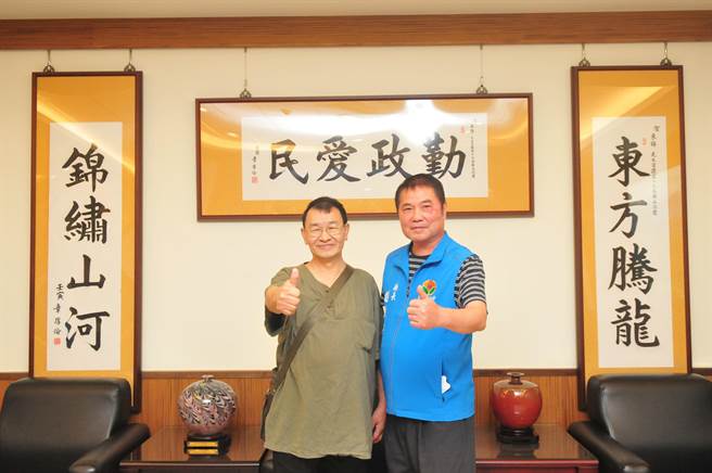 锺东锦在章厚伦的墨宝前与他合照。（苗栗县政府提供／李京升苗栗传真）