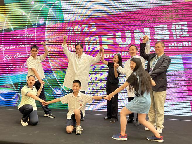 桃园市长张善政、教育局长刘仲成换上实验衣，化身科学家与学生一起玩科技，示范人体导电。(蔡依珍摄)