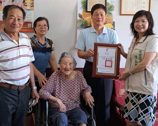 石宪谕（右二）为照顾母亲提前退休至今10年，今年获颁台南市孝行奖。（张毓翎摄）