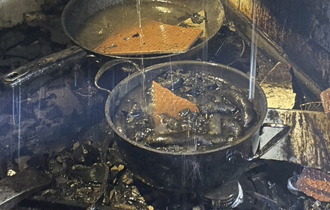 新北市蘆洲今(29)日下午1處民宅發生火警，其屋主因在煮香腸煮到睡著，而整鍋香腸也變成「黑炭香腸」。（新北消防局提供）