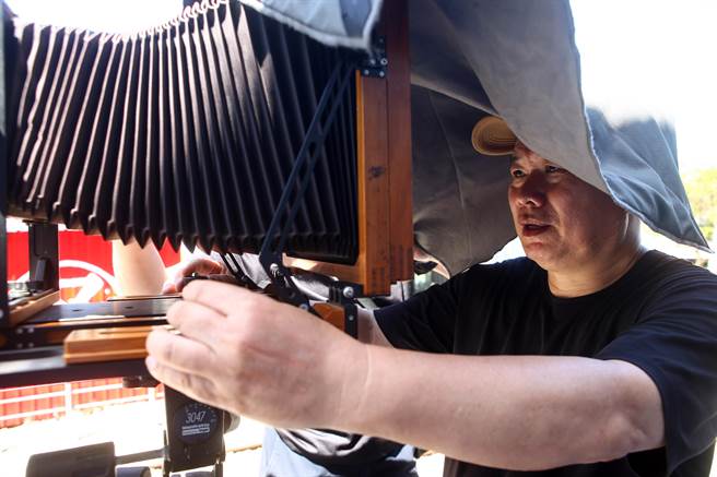 林添福示范大型相机操作过程。（邓博仁摄）