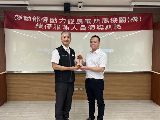劳动力发展署署长蔡孟良颁奖表扬年度绩优服务人员，右为最佳训练师夏云清。(中彰投分署提供)