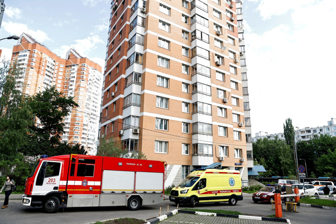 莫斯科地方政府称，当地30日清晨遭到无人机攻击，数栋建筑遇袭。图为救护车及消防车停在其中一栋公寓大厦外。（图／路透社）