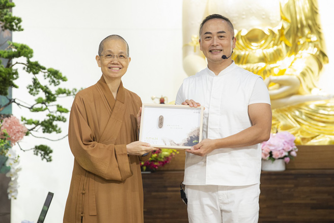 佛光山中区总住持觉居法师致赠讲座结缘品予彦宽老师。（图／惠中寺提供）