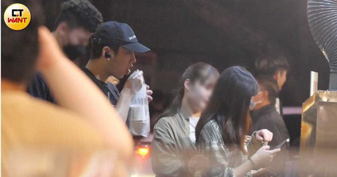 戴着帽子独自出门觅食的陈慕，在等待餐点时，已迫不及待吃起手中已有的餐点。（图／本刊摄影组）