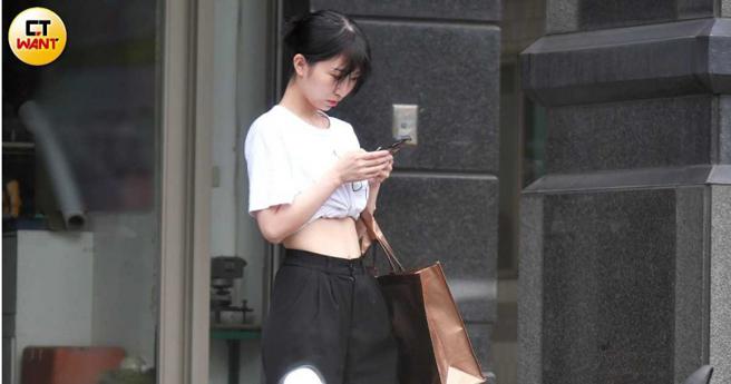 艷阳高照下，藤井麻由穿着轻便在自家门口等人边滑手机。（图／本刊摄影组）