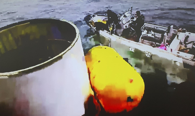 南韩军方表示，已回收推测为连结第一节及第二节火箭的圆筒形物体，正在海中持续打捞其余部分。（图/ 美联社）