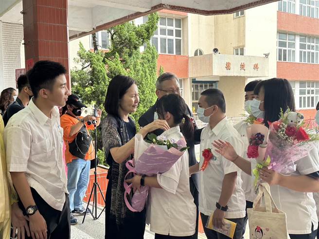 花莲私立四维高中今天举办毕业典礼，儘管颱风搅局，仍浇熄不了毕业生的热情，离开校园前特别拥抱董事长黄淑怡跟校长蔡忠和。（罗亦晽摄）