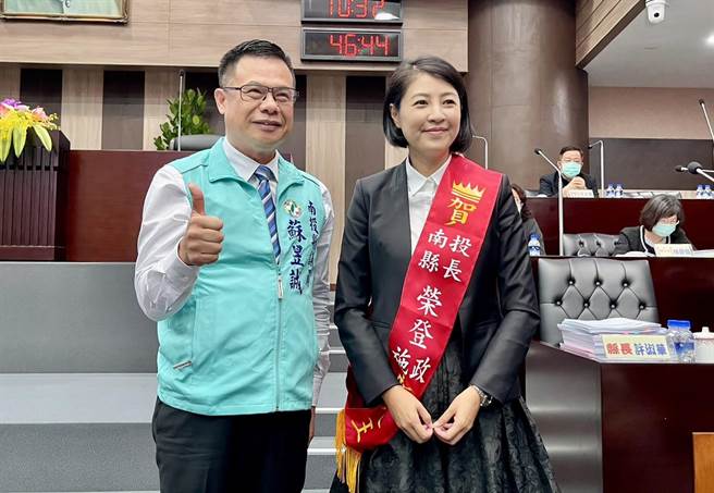 南投县议员苏昱诚赠送县长许淑华「荣登施政新人王」彩带，要求垫底的环保局、卫生局积极努力提升满意度，把名次拉高。（杨静茹摄）