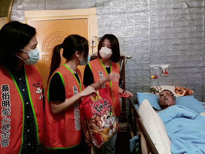 蔡衍明爱心基金会与逢甲大学学生探视瘫痪的弱势户。（陈淑娥摄）