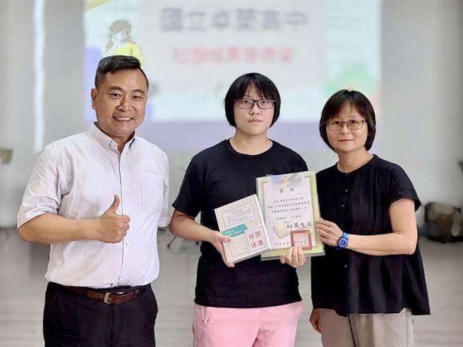 国立卓兰高中毕业生刘妍秀（中）在校6年借阅数居冠，校长张智惟（左）颁给她阅读楷模奖。（卓兰高中提供／谢明俊苗栗传真）