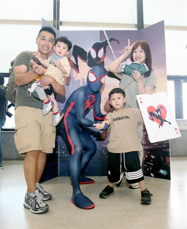 旅客登机前开心地与蜘蛛人合影留念。（范扬光摄）