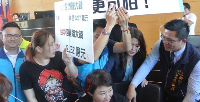 罗廷玮在台中市议会举牌，尽量避免身体接触。（图取自罗廷玮脸书）