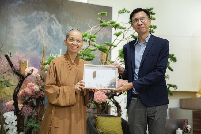 佛光山中区总住持觉居法师（左）致赠结缘品予朱为民医师（右）。（图／惠中寺提供）
