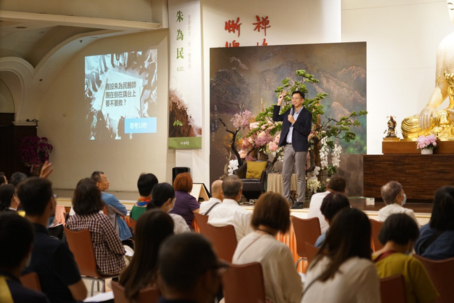 朱为民医师问听眾，假如演讲时他突然倒在台上，会不会救他？这是需要思考再决定的问题。（图／惠中寺提供）