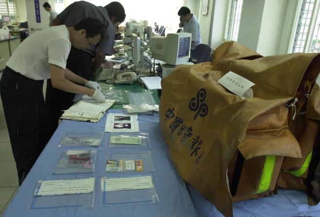 警方整理相关证物，包括钱莺莺派报用的报袋（右），内还有约3万元现金。（本报资料照片）