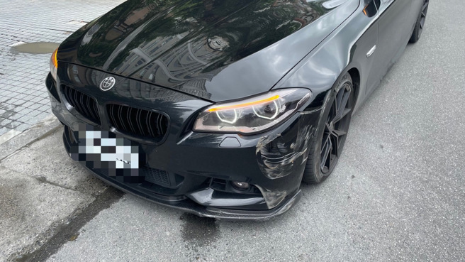 黑色轿车遭滚动滑行的轮胎撞击，导致左前车头回损。（图／警方提供）