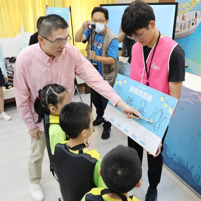基隆市长谢国梁（左）带小朋友玩常被搞错的锁管、花枝、小卷、鱿鱼、软丝等海洋生物的「连连看」。（基隆市政府提供／徐佑升基隆传真）