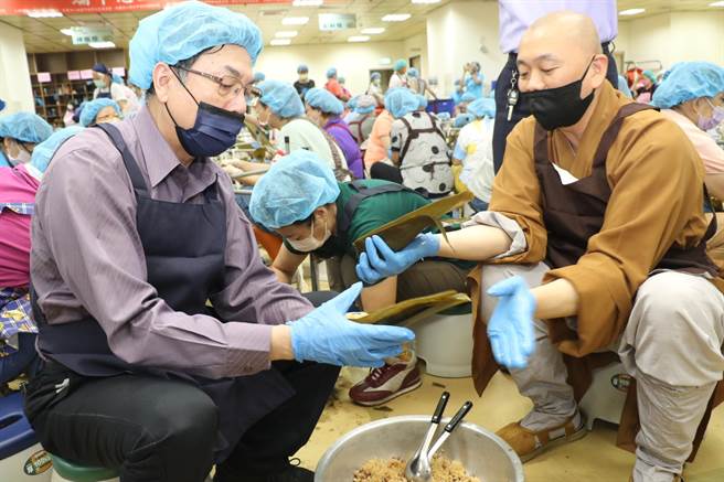 新北市副市长刘和然（左）在会常法师（右）的指导下，包了生平第一粽，他说要献给新北市好日子爱心大平台。（陈慰慈摄）