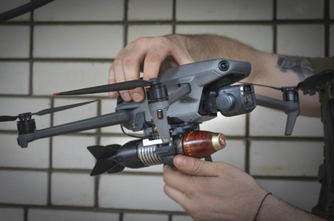 乌克兰军官在无人机上安装炸弹的画面。（美联社）