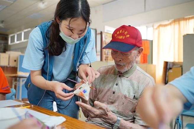 桃园市青年志工陪伴石门社区长辈，体验彩绘造型零钱包活动。（青年局提供／蔡明亘桃园传真）