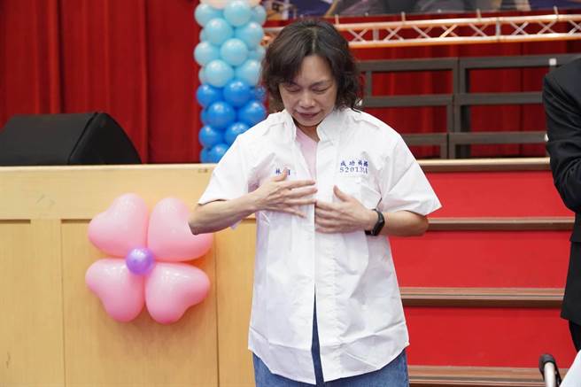 林月香3年来不辞辛劳地伴读罹患重度脑性麻痹儿子何彦宝，台北市成功高中颁给她荣誉毕业证书，并送上绣有姓名的成功高中校服。（成功高中提供）