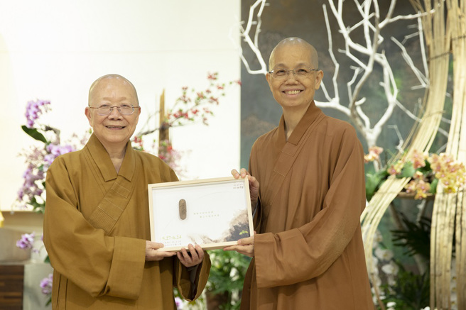 佛光山中区总住持觉居法师（右）致赠结缘品予讲师依空法师（左）。（图／惠中寺提供）