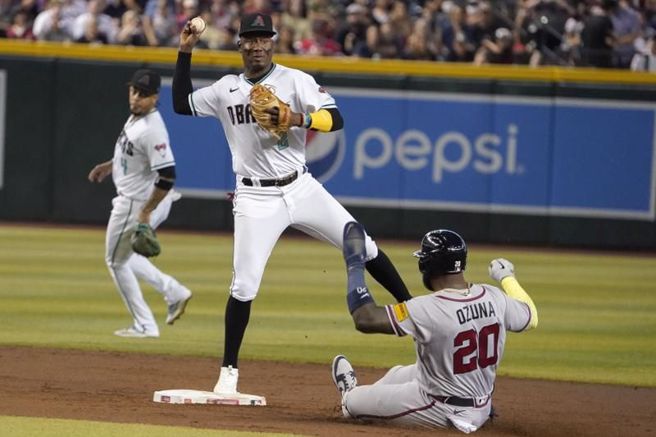 勇士欧苏纳(右)衝二垒遭到封杀。（美联社）