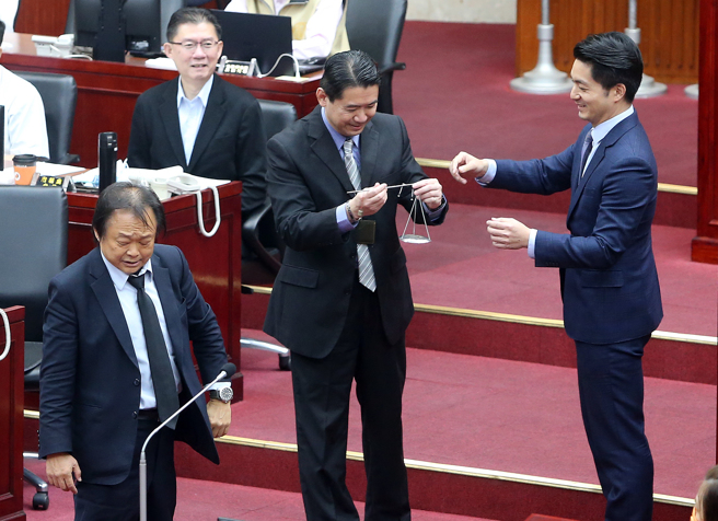 民进党台北市议员王世坚（前左）5日在市政总质询上送给台北市长蒋万安（前右）秤子，表示蒋万安身为首都市长，要自我期许「我心如秤」，公正秤量各项市政建设、资源分配，放下政党成见，当全民市长。（赵双杰摄）