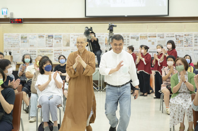 讲师台中荣总李旭东医师(右)在佛光山中区总住持觉居法师(左)陪同下进场，受到观眾热烈欢迎。（图／惠中寺提供）