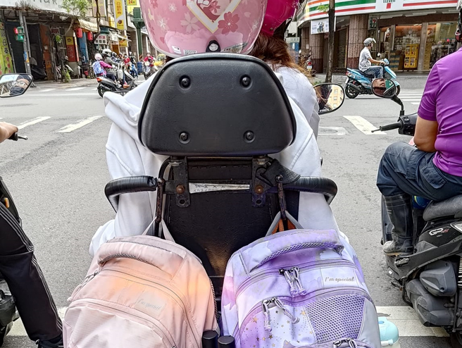 1名骑士发现有位妈妈骑机车载小孩，然而后方安全座椅上的2个书包，却挡住了机车方向灯，让他感到非常危险。（翻摄自脸书爆怨公社）