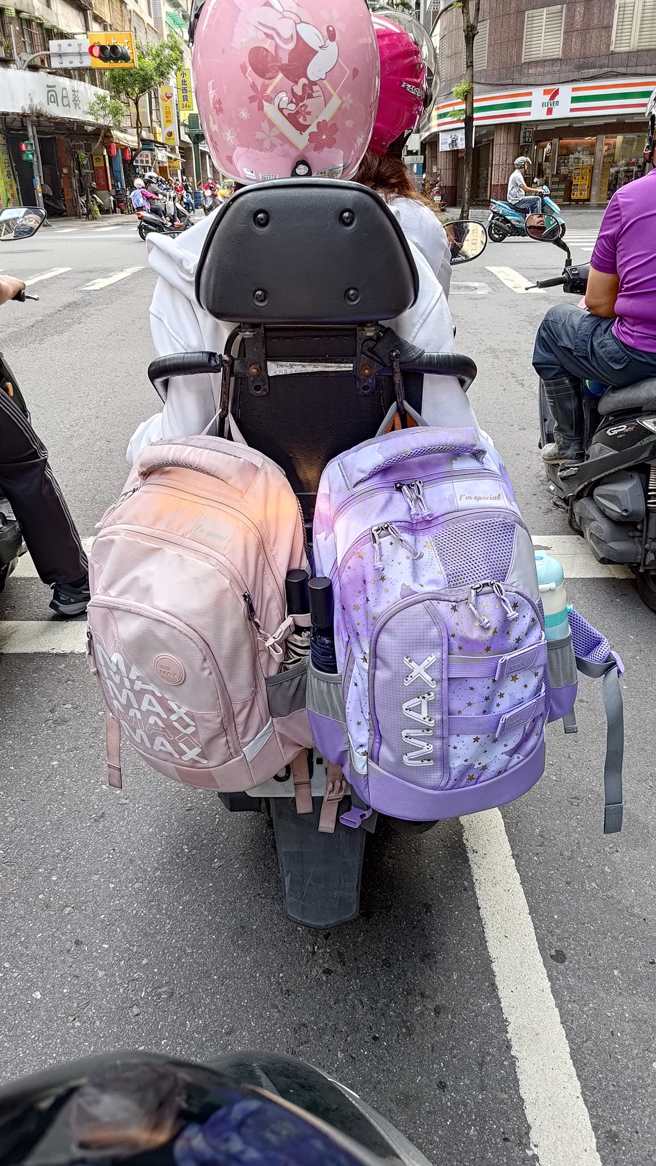 1名骑士发现有位妈妈骑机车载小孩，然而后方安全座椅上的2个书包，却挡住了机车方向灯，让他感到非常危险。（翻摄自脸书爆怨公社）