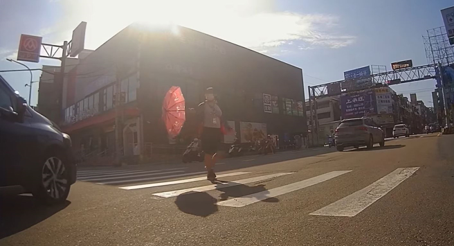 女行人走斑马线拿起雨伞挡车。（翻摄自脸书爆料公社）