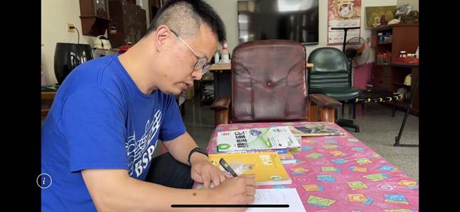 黄锦荣为鼓励明年参加国中会考的女儿，重拾书本报名今年国中会考。（孙英哲摄）