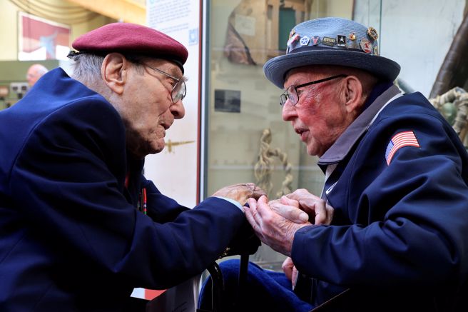 100岁的拉森与99岁的格雷登（左）5日相见，紧握彼此双手。（路透）