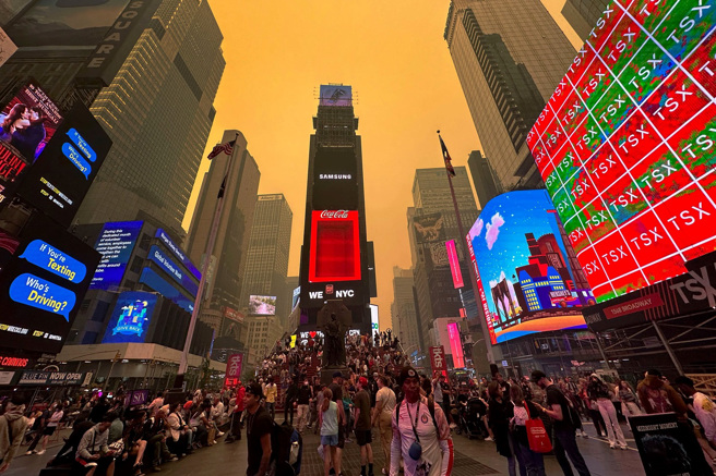 受到加拿大野火烟雾飘向南方影响，纽约市空气品质严重下滑，成为全球最糟，整座城市染成橘红色。图为时报广场7日景象。（图／路透社）