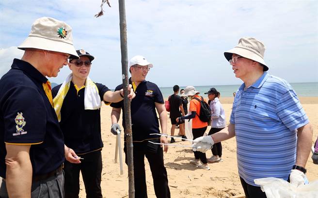 日月光环基会执行长汪渡村（右一）携手内政部警政署黄明昭（左一），在福隆海水浴场捡拾沙滩上的垃圾。（警政署提供）