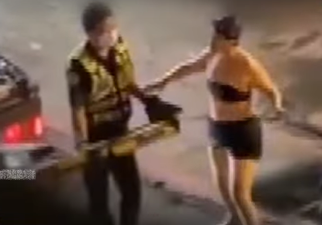 妇人见爱车要被拖走，不顾身上仅穿泳衣、戴泳帽，仍跑到员警身旁苦求别拖走。（图/中天新闻）