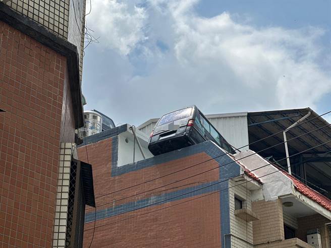 台中北区一处透天顶楼被民眾发现有「双车位」，其中一台厢型车车尾就卡在女儿墙上，屋主曾允诺会吊下来，却无疾而终。（民眾提供／冯惠宜台中传真）