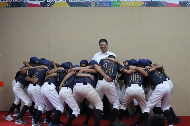 替新竹县争取赛事荣誉的小球员们围着县长杨文科高喊队呼。（邱立雅摄）