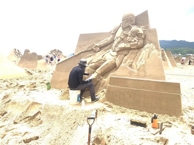 ▲工作人员正在制作沙雕。（徐佑升摄）