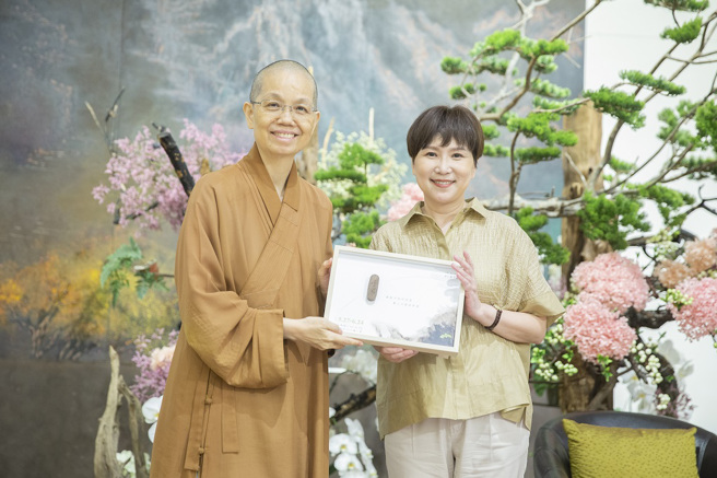 佛光山中区总住持觉居法师（左）赠送结缘品给讲师詹庆龄（右）。图／惠中寺提供