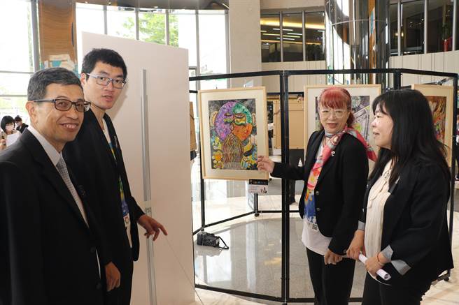 台湾星奇儿创艺协会创会理事长陈颖君（右2）为板信商银副总经理黄新茂（左1）和社会局副局长吴淑芳（右1）解说星奇儿创作马偕博士画像。（新北市社会局提供）